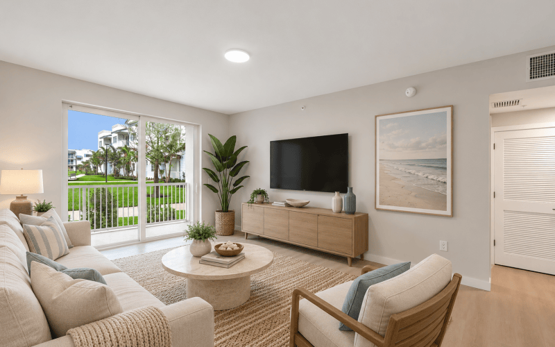 Bright modern living room with balcony views at Shalimar at Boynton Beach apartments in Boynton Beach, Florida
