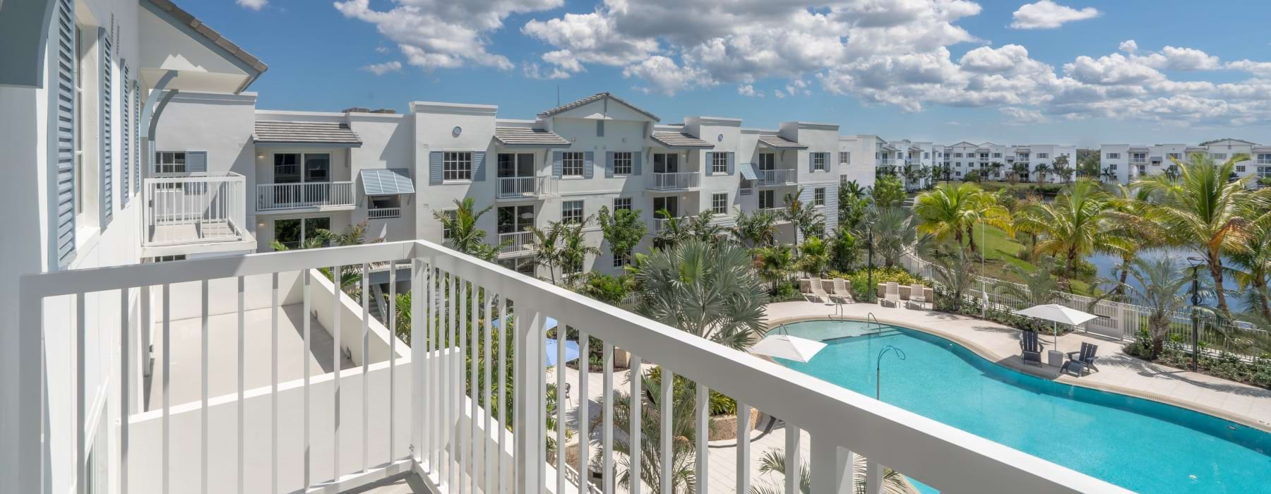 Private apartment balcony overlooking the resort-style pool and landscaped community at Shalimar at Boynton Beach in Florida