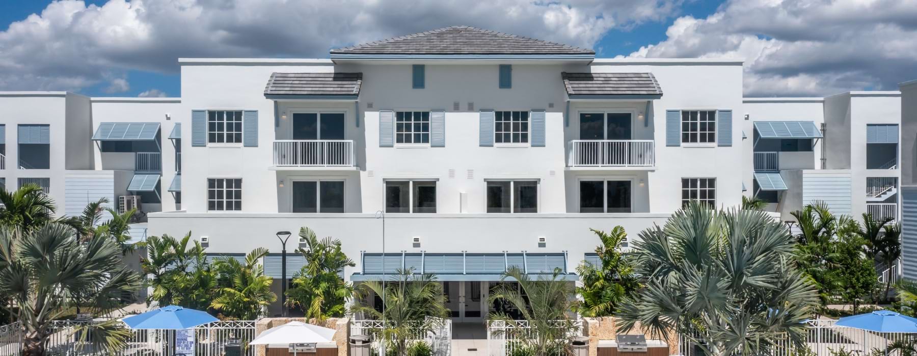 Modern apartment building exterior facing the resort pool and tropical courtyard at Shalimar at Boynton Beach.